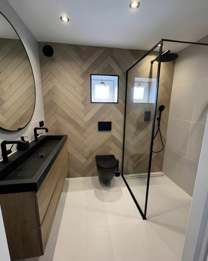 Modern bathroom with herringbone wall tiles, wall-hung WC and walk-in shower